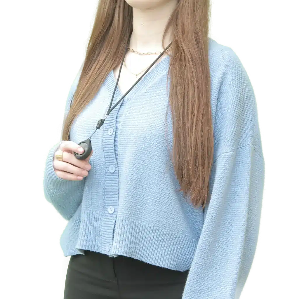 Woman in a pale blue cardigan wearing lanyard with the bluetooth button